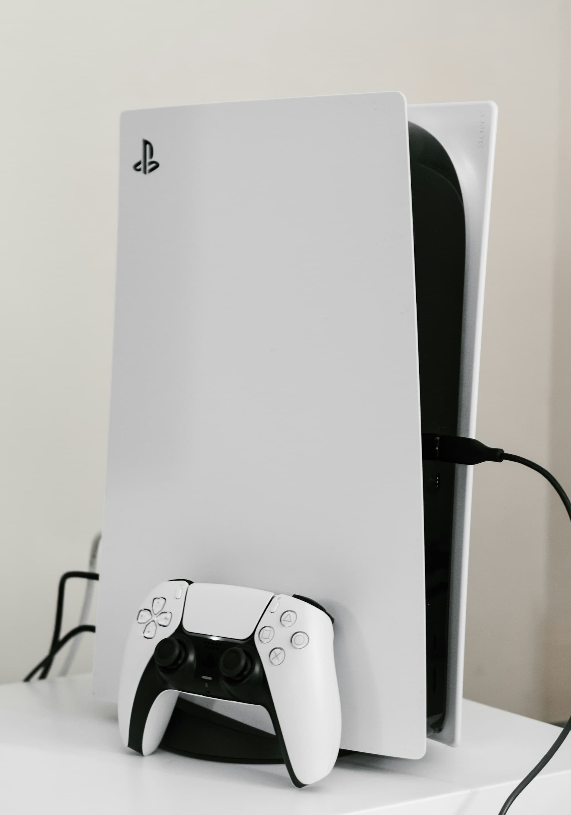 A white PlayStation 5 console beside its controller